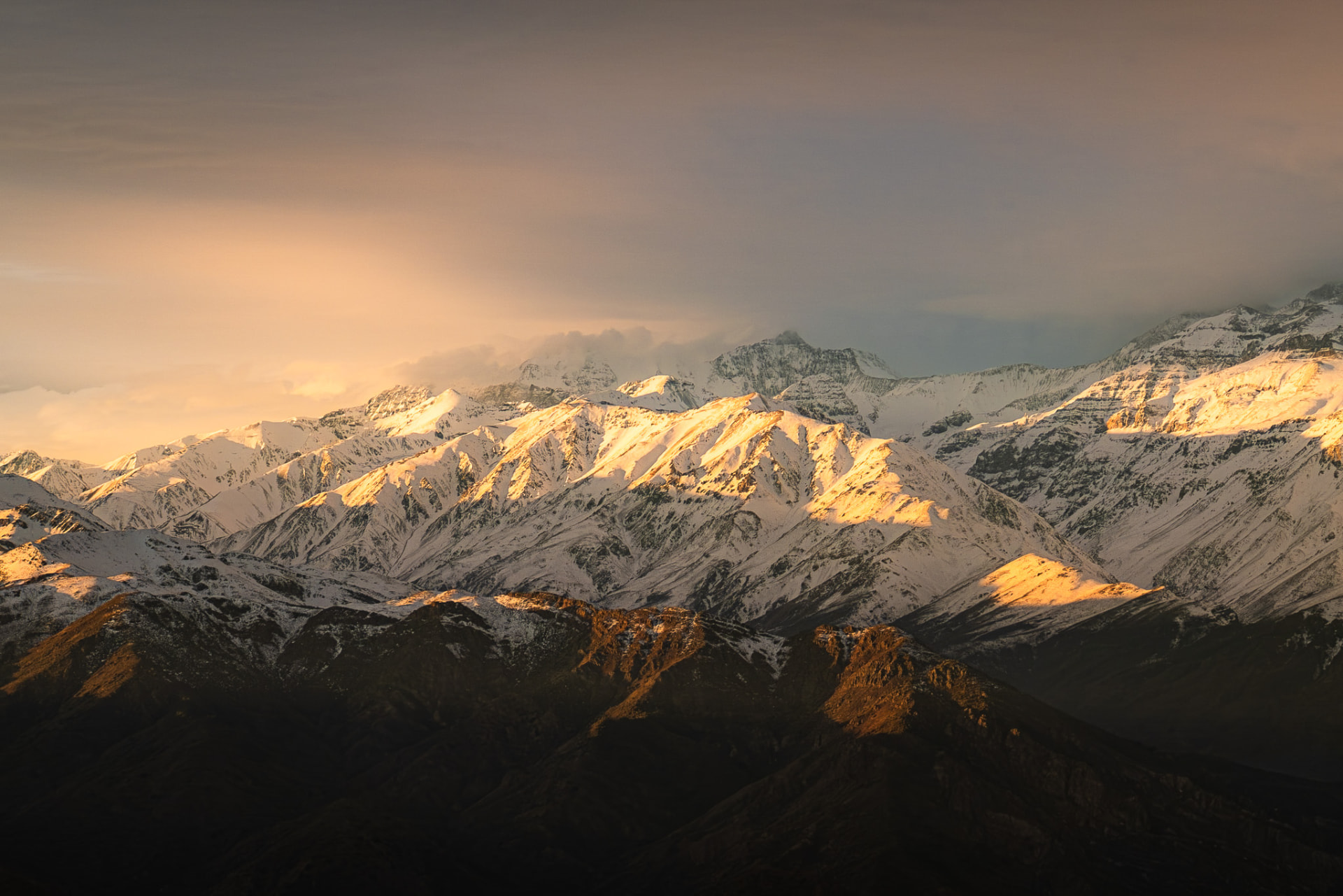 Cumbre de la cordillera de los Andes sobre un mar de nubes al amanecer